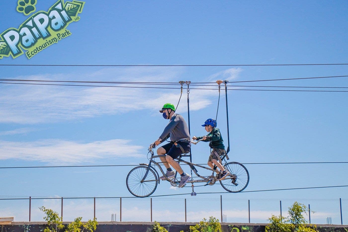 Tándem-bike en tirolesa cruzando el parque contra cielo abierto